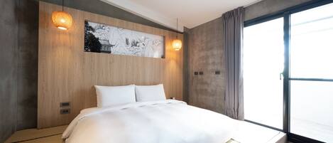 Une chambre d’hôtel moderne avec un grand lit, une tête de lit en bois et une grande fenêtre avec des rideaux.