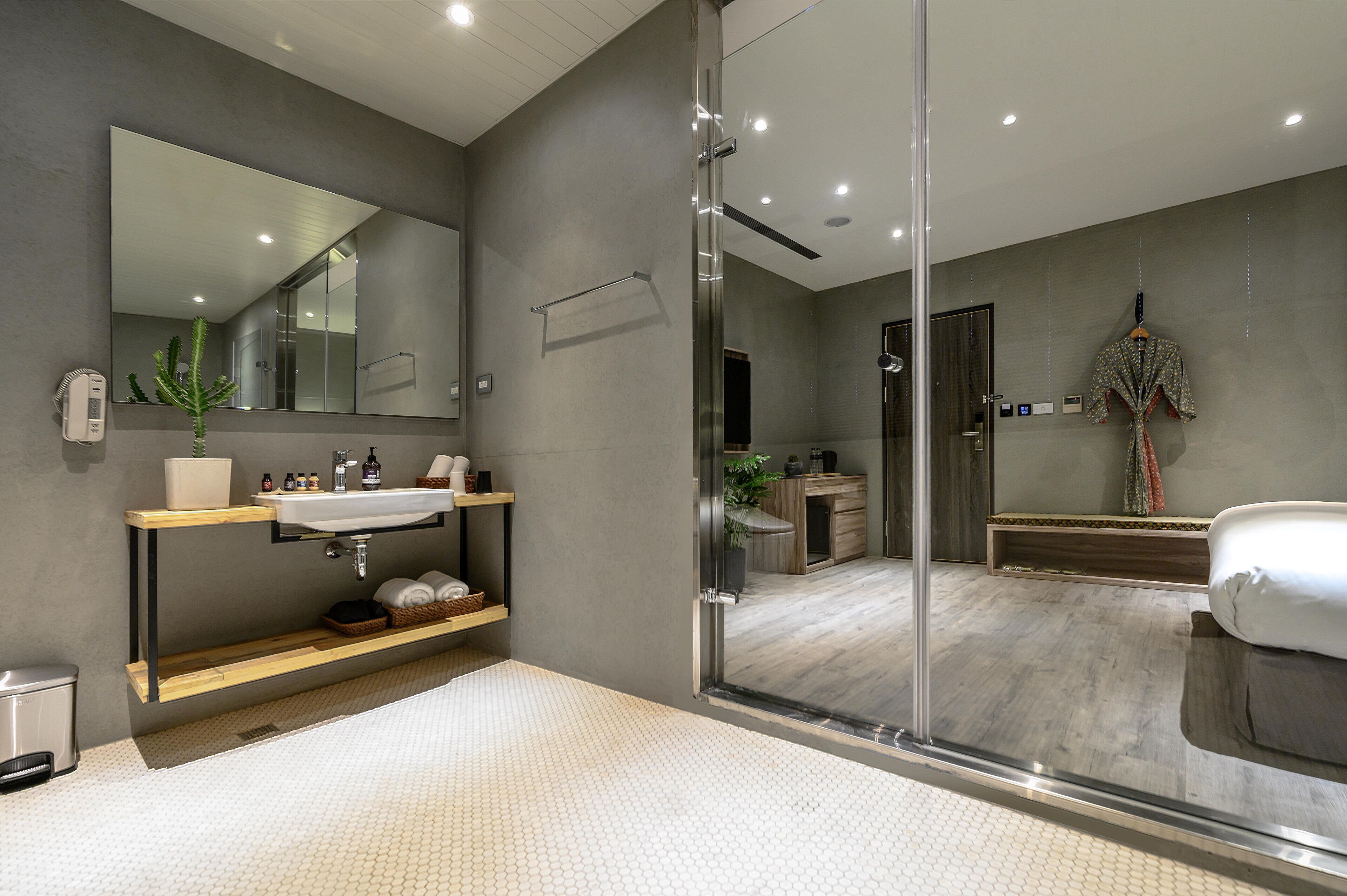 Un bagno moderno con box doccia in vetro, uno specchio grande e un mobile lavabo in legno.