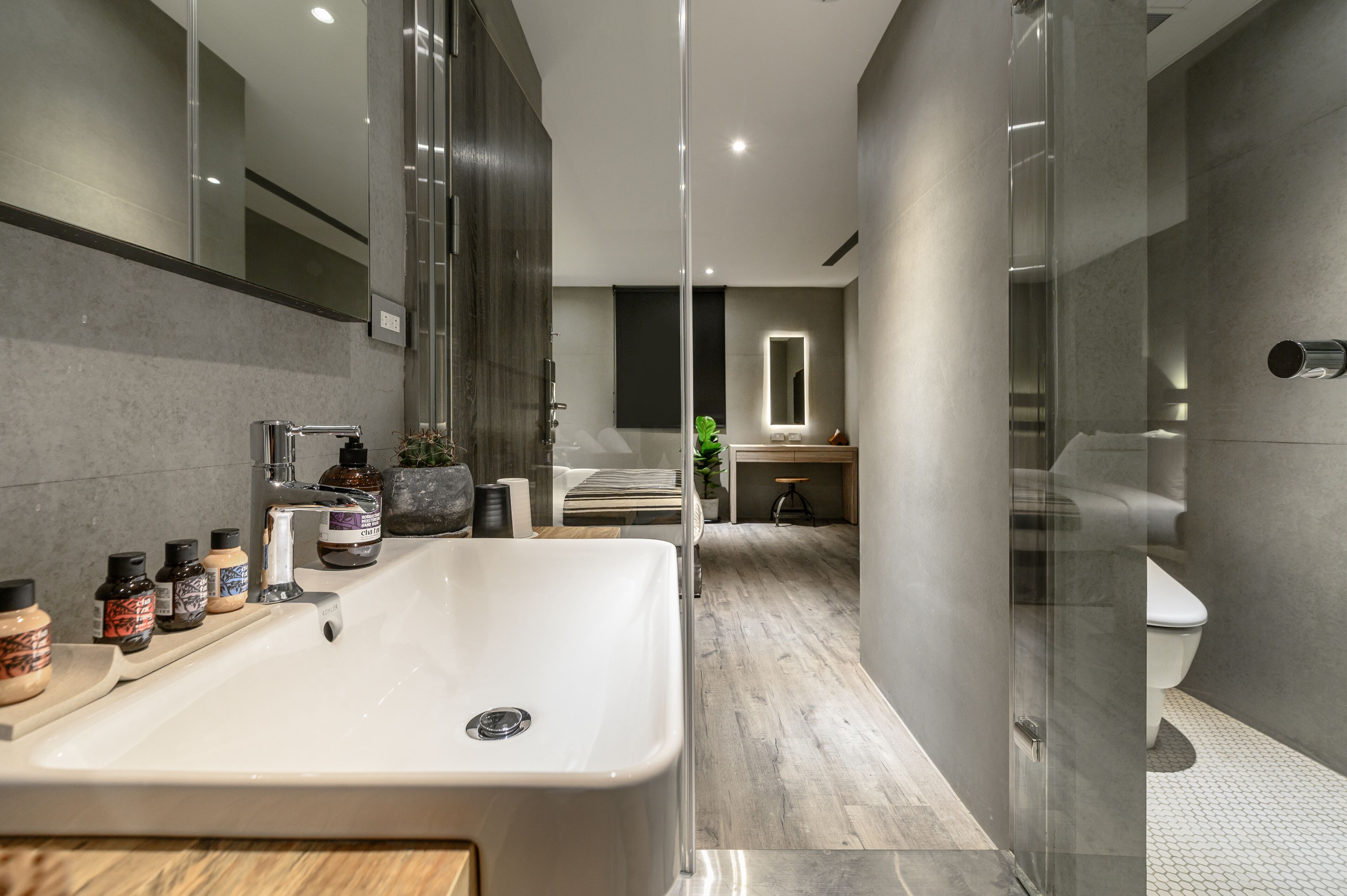 Een moderne badkamer met een ruime wastafel, een douchecabine met glazen wanden en een toilet.