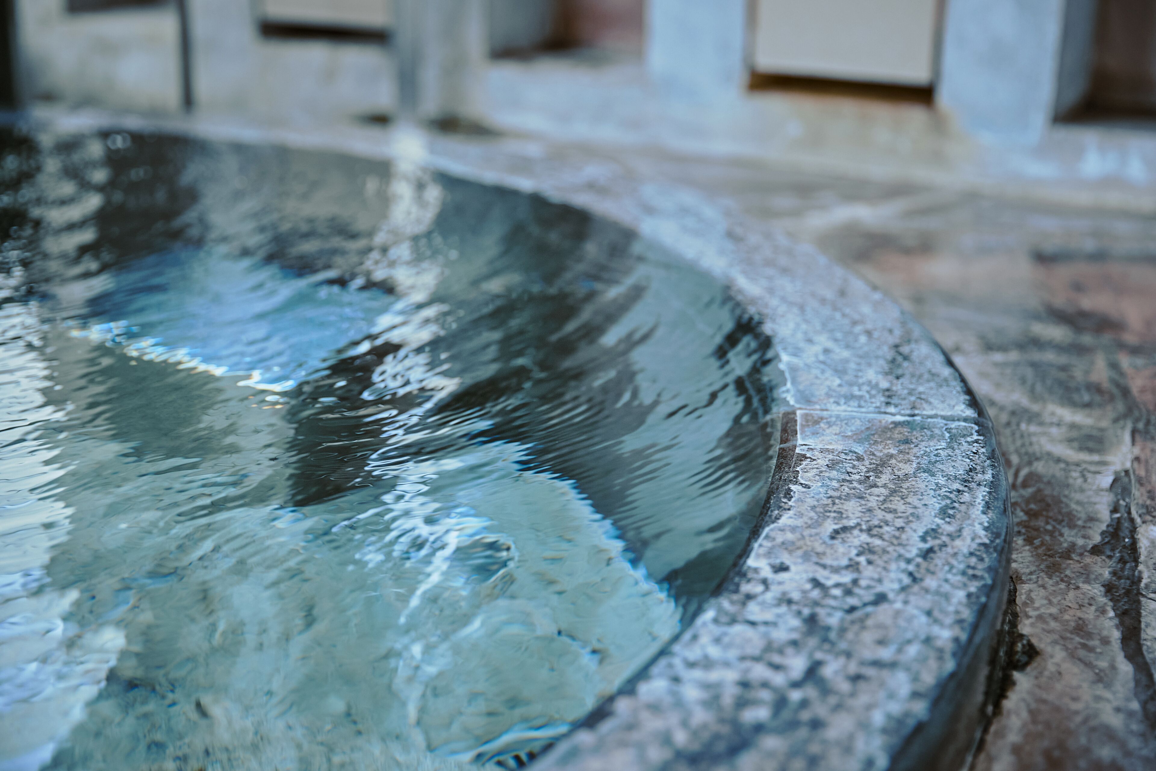 A stone basin with water, likely part of a bathroom or spa area.