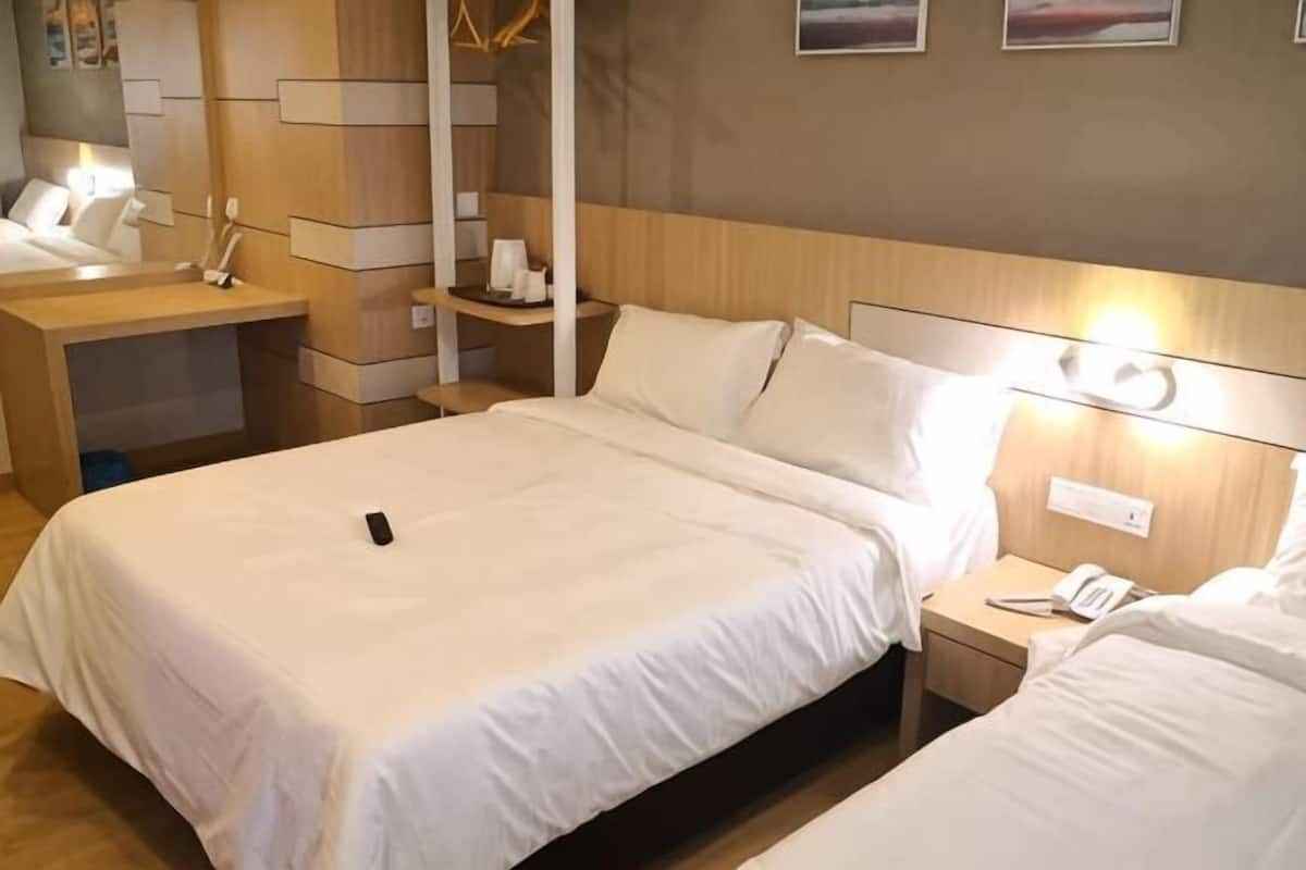 Quarto de hotel com uma cama grande, mesas de cabeceira, escrivaninha e uma cadeira.
