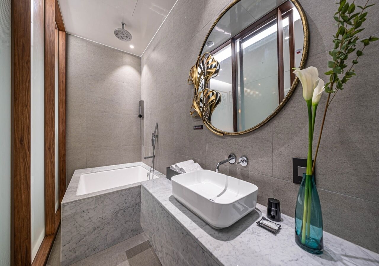 A modern bathroom with a freestanding bathtub, a vanity with a sink, and a large mirror.