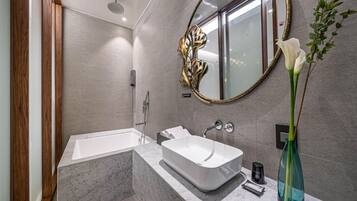 A modern bathroom with a freestanding bathtub, a vanity with a sink, and a large mirror.