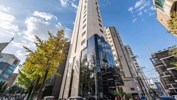A tall, modern building with a glass facade and multiple floors. - Forestar (Seoul)