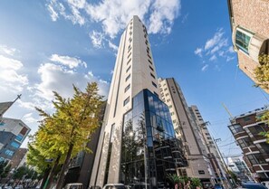 A tall, modern building with a glass facade and multiple floors. - Forestar (Seoul)