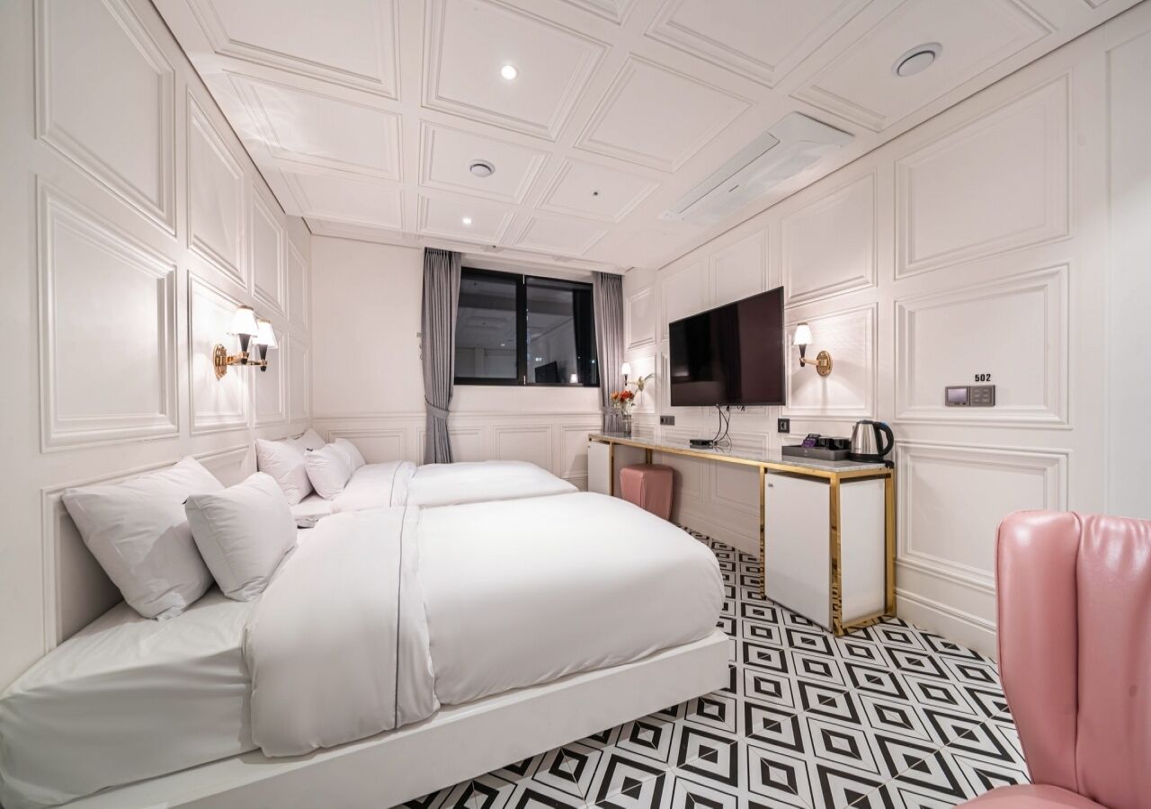 Een hotelkamer met een groot bed, een bureau, een televisie en een stoel.