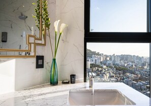 Bañera con ducha, artículos de tocador de diseñador, secador de pelo