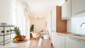 Une cuisine moderne avec des armoires blanches, un plan de travail en bois et un évier en acier inoxydable.