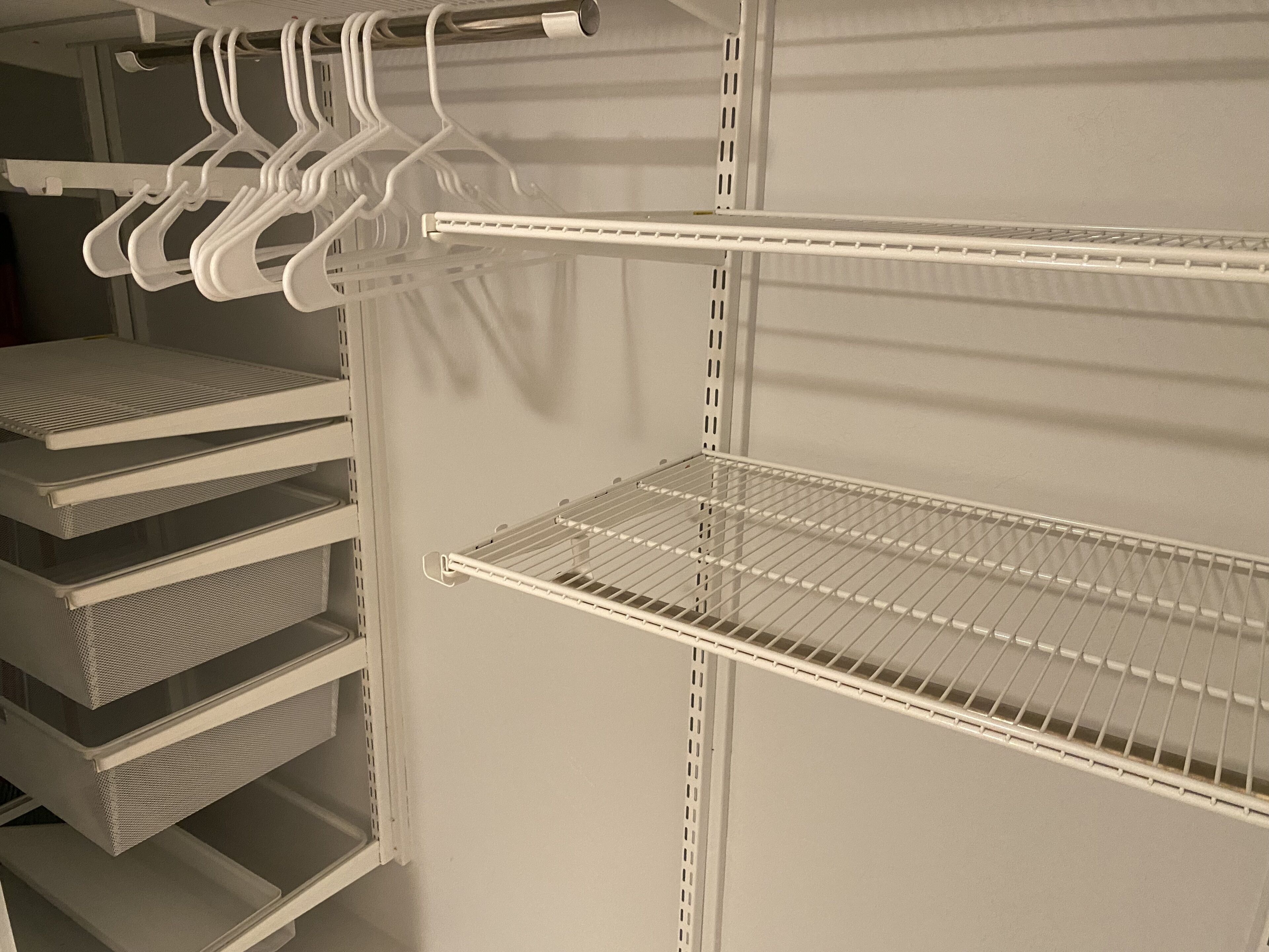 A storage closet with shelves, hanging storage, and a metal rack.