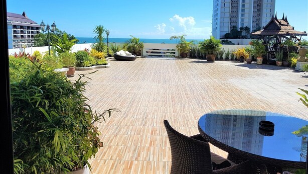 Eine Dachterrasse mit Meerblick, Kübelpflanzen und einem Gazebo.