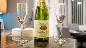 A bottle of Martinielli sparkling cider and two empty glasses on a kitchen counter. - THE ONE!! Spa⁕Heated Pool⁕Fire Pit ⁕Putting Green  (Peoria)
