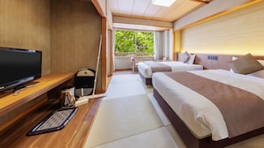Ein Hotelzimmer mit Fernseher, Schreibtisch und zwei Betten.