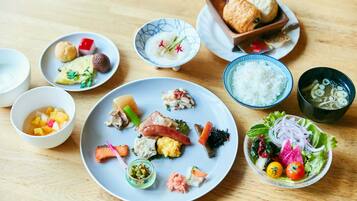 A variety of dishes on a wooden table, including rice, vegetables, and meat.