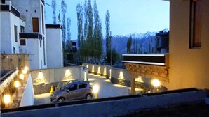 Un espace de stationnement avec une voiture, entouré de bâtiments et d’arbres.
