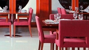 A dining area with multiple tables and chairs, each set with plates, glasses, and cutlery. - Craven Cottage Inn (Lagos)
