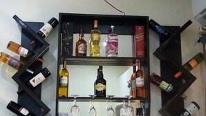A wine rack with multiple bottles and glasses. - Craven Cottage Inn (Lagos)