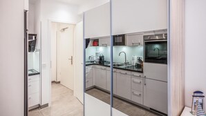A modern kitchen with a stainless steel oven, a sink, and a coffee maker.