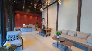 Un interior moderno con mostrador de recepción, zona de estar e iluminación decorativa.