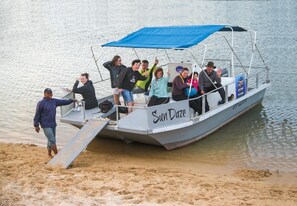 Un barco llamado 'Sun Daze' con cubierta techada y pasajeros.