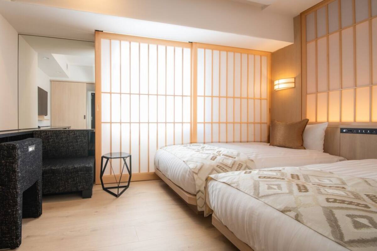 Una habitación de hotel con una cama, un escritorio, una silla y un televisor.