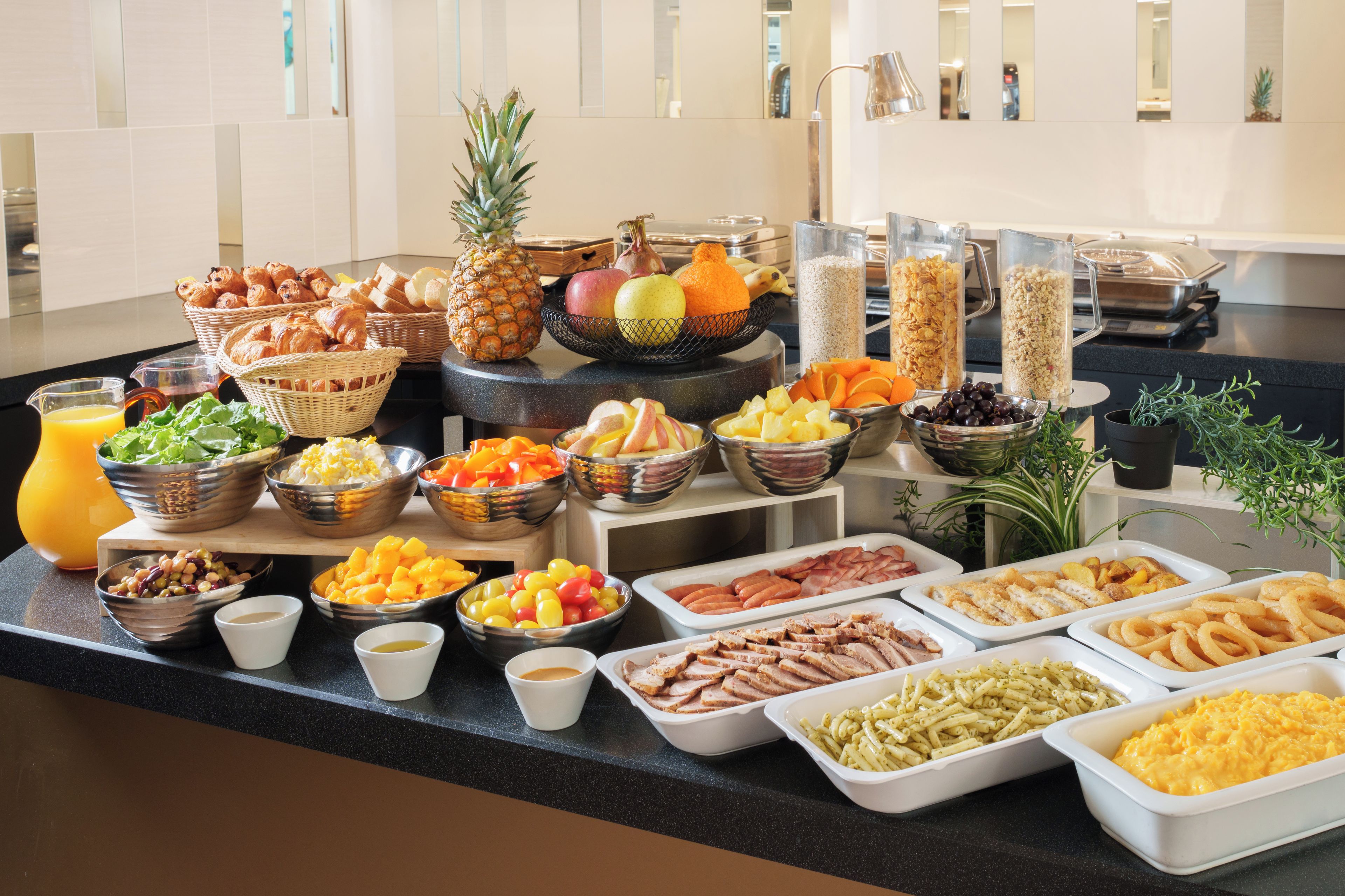 A buffet with various food items including fruits, vegetables, and meats.