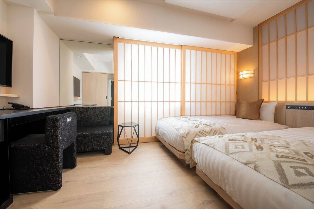 Una habitación de hotel moderna con una cama, un escritorio y una silla.