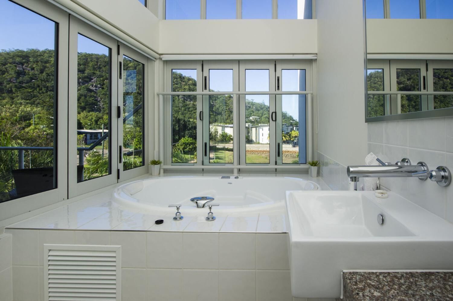 Ein modernes Badezimmer mit einer großzügigen Badewanne, einem separaten Waschbecken und einer Dusche mit Glastrennwand.