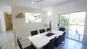 A dining area with a white table and black chairs, a ceiling fan, and a view through a glass door to the outside. - BrookeHaven (Arcadia)