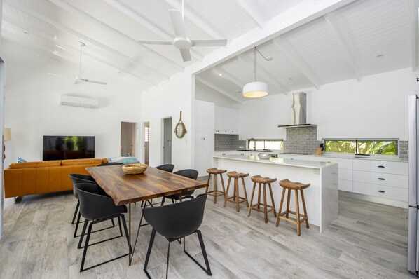 Una cocina moderna con muebles blancos, una isla grande y una estufa empotrada.