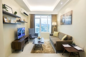 Spacious Clean 1 Bedroom near Ayala Mall | Living area | TV, fireplace, pay movies - Comfy Suites at The Padgett Place (Cebu City)