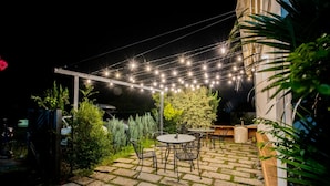 An outdoor patio area with stone flooring, metal chairs, and tables. - Dream Valley (Beinan)