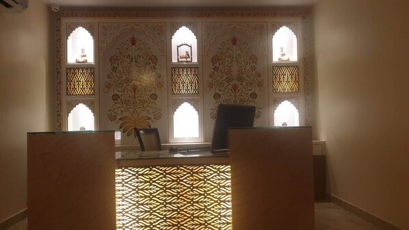 A room with a glass partition, a patterned wall, and a decorative screen.