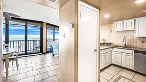 A kitchen with white cabinets, a stainless steel dishwasher, and a tiled backsplash.
