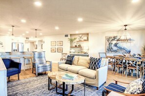 A spacious living area with a sofa, chairs, and a dining table.