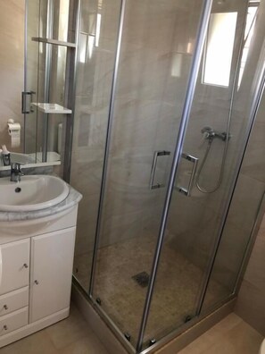 Chuveiro, secador de cabelo, toalhas de banho, shampoo
