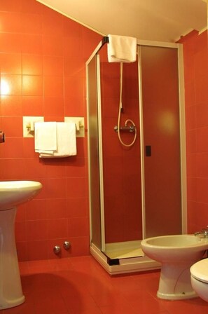 Un baño con ducha, lavabo y bidé.