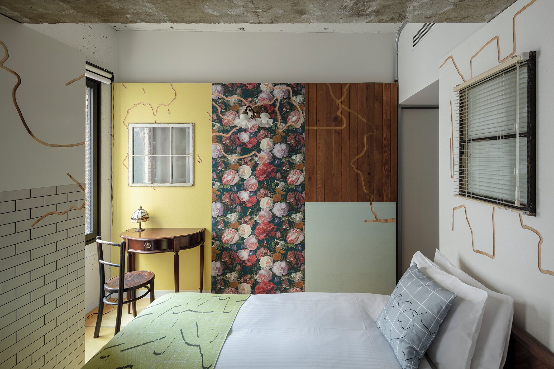 A bedroom with a bed, a chair, a small table, and a window.