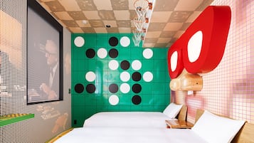 Relax in a stylish room with a large bed, vibrant artwork, and a fun basketball hoop.