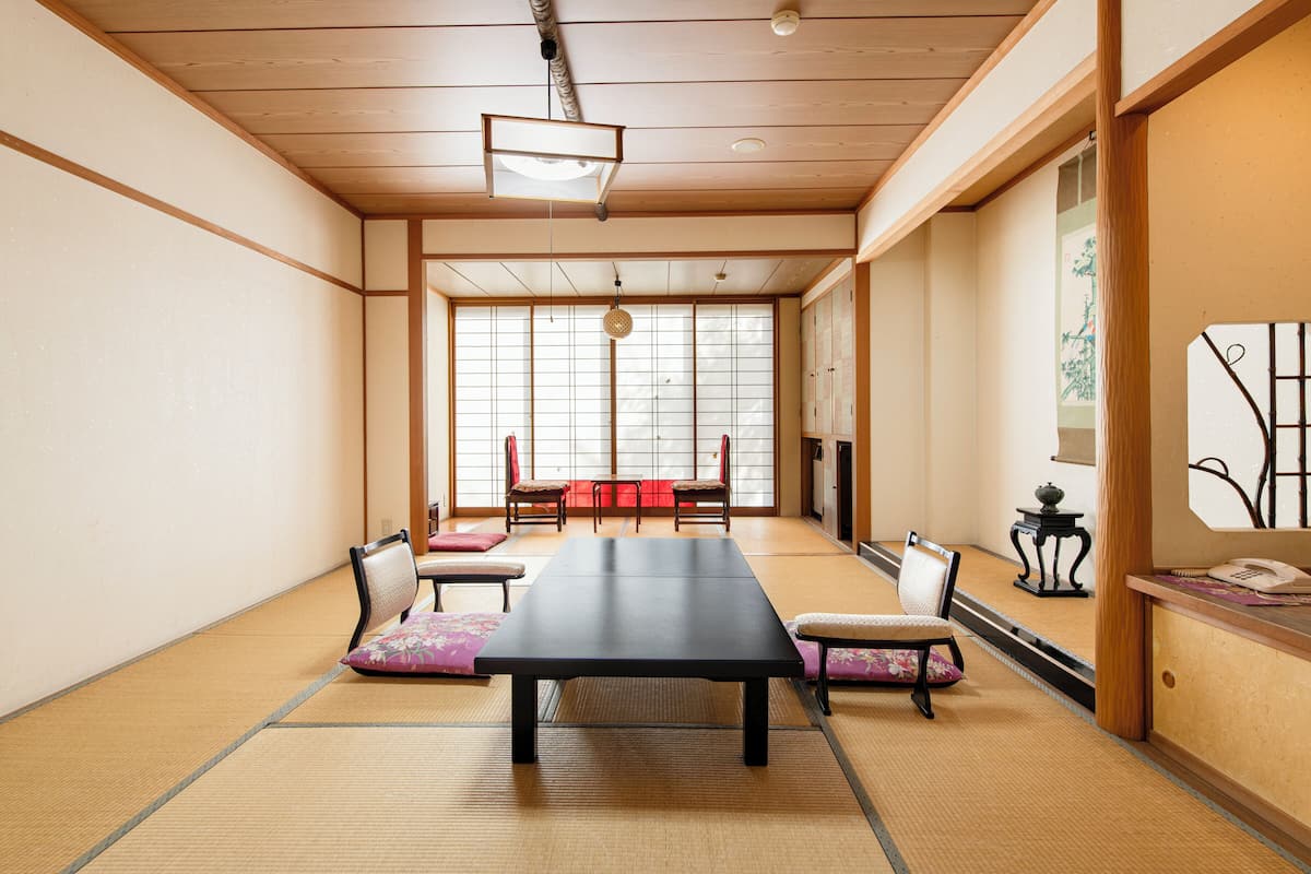 A traditional Japanese room with tatami flooring, a low table, and shoji screens.