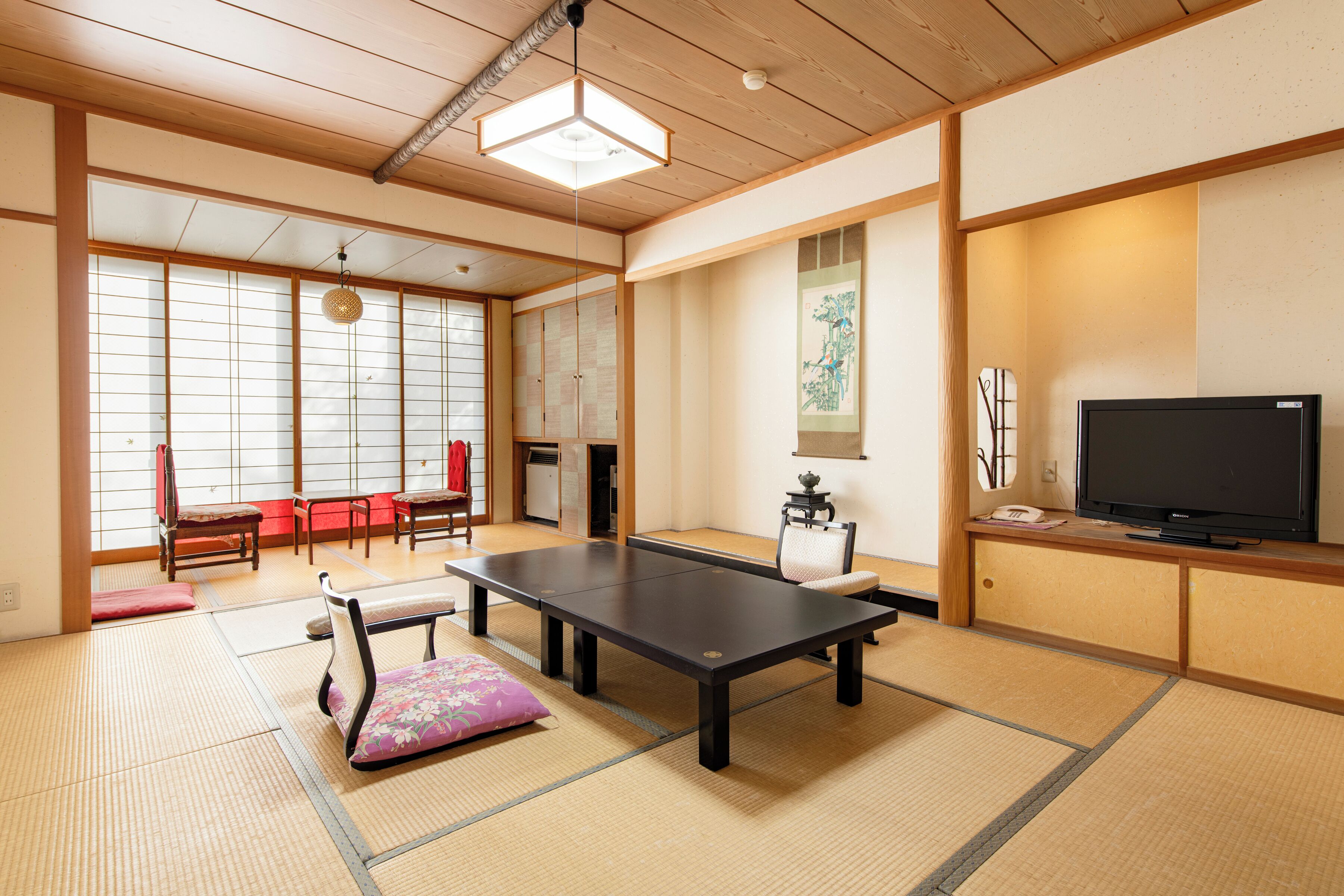 Et rum med tatamimåtter, et tatami-bord, et fjernsyn og traditionel japansk indretning.