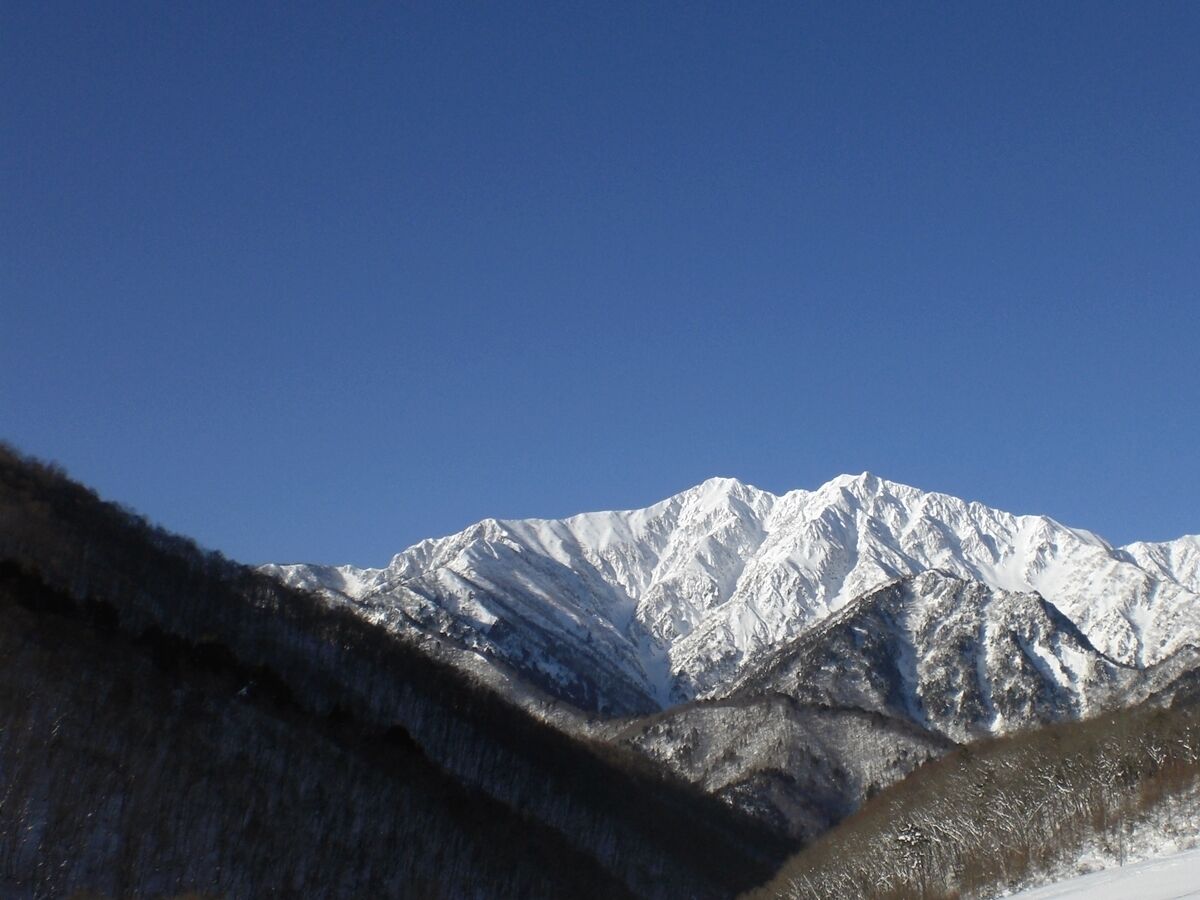 A snow-covered mountain range with a clear blue sky.