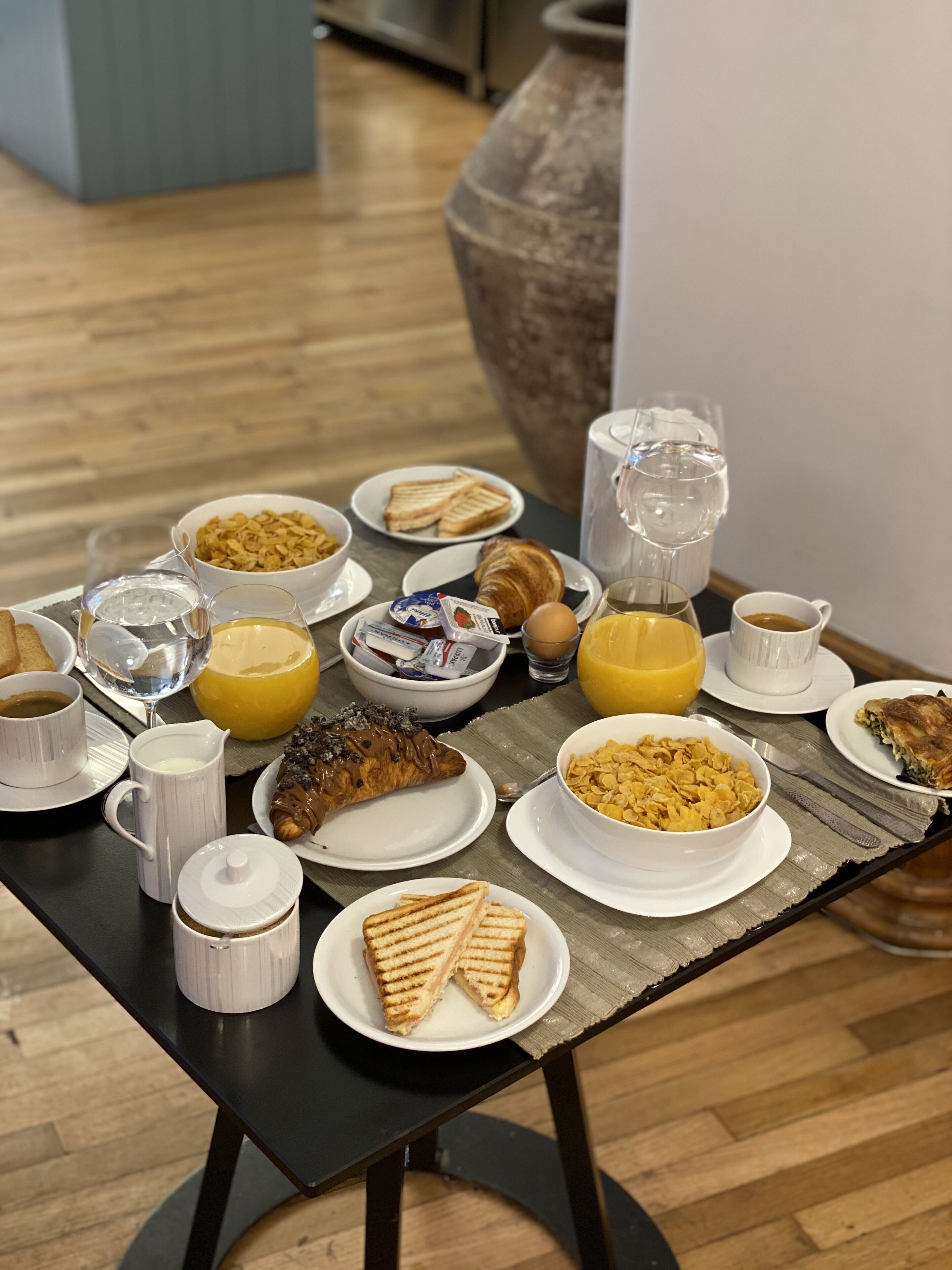 A breakfast table with various food items and drinks.