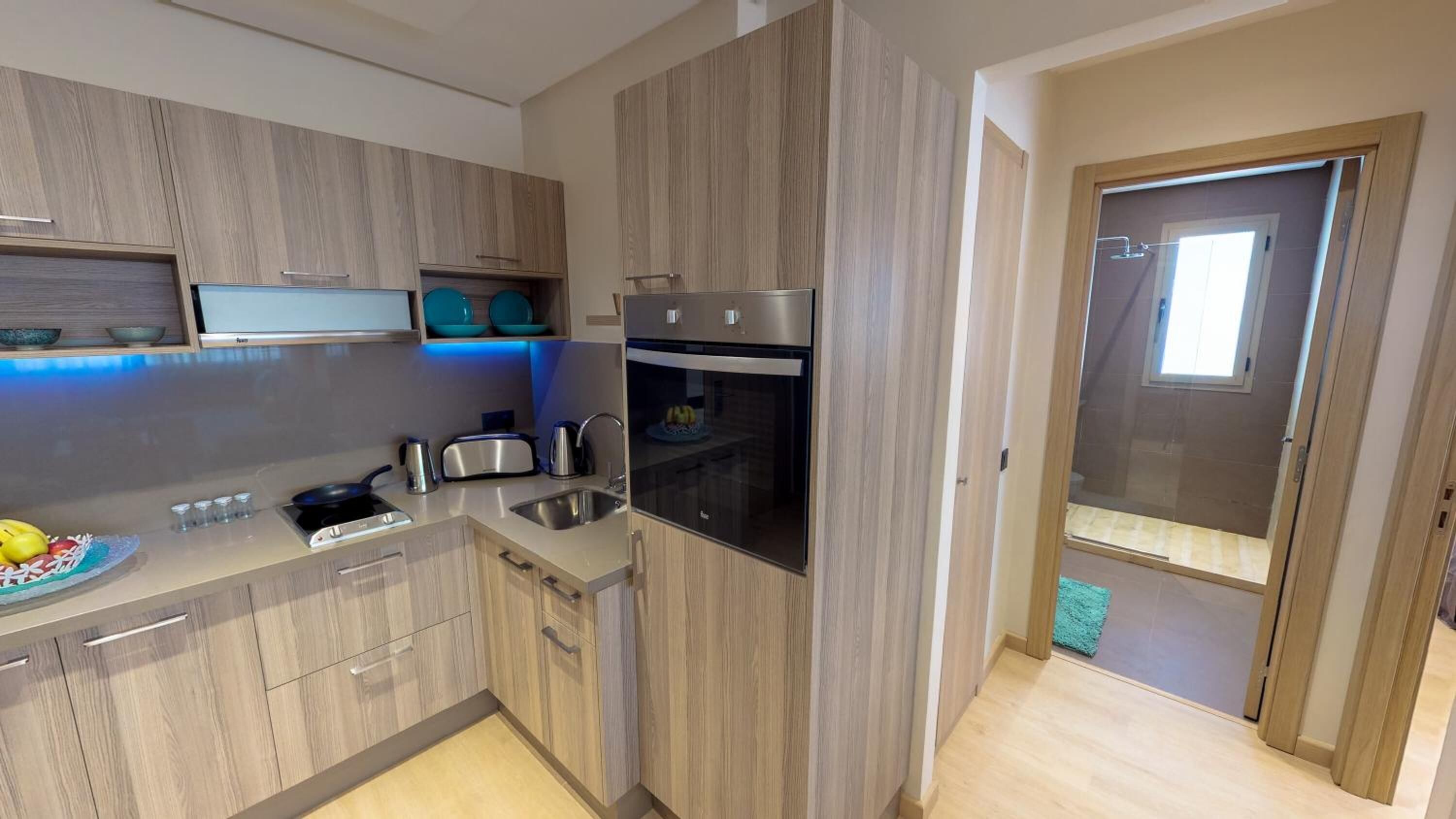 A modern kitchen with wooden cabinets, a built-in oven, and a sink.