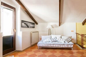 Un dormitorio con cama, un radiador, un cuadro en la pared y una ventana.