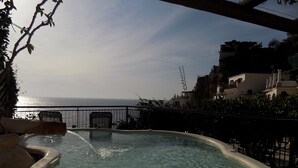Ein Whirlpool mit Meerblick, umgeben von einem Balkon mit Geländer.
