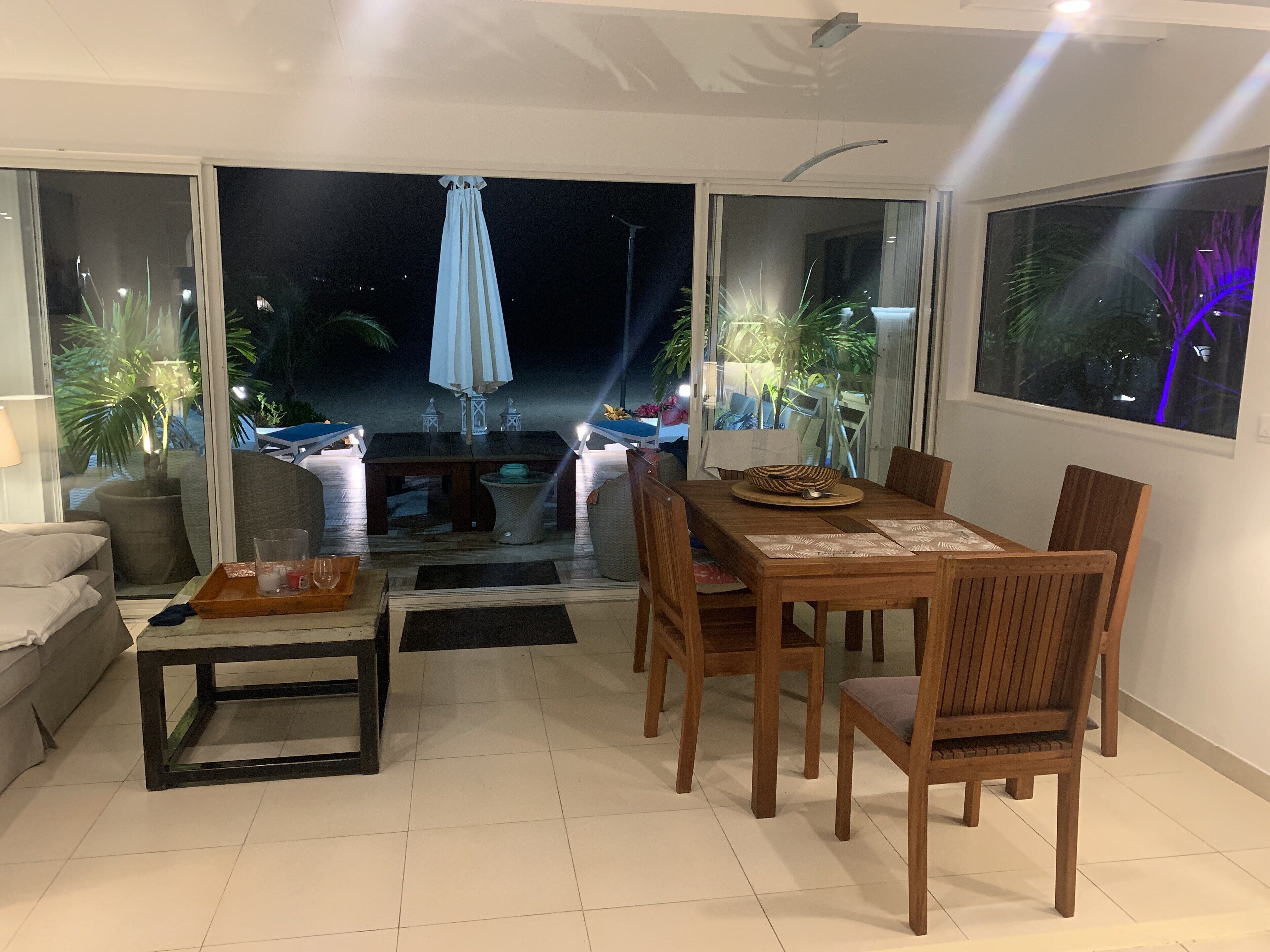A dining area with a table and chairs, a sofa, and a small table with a tray.
