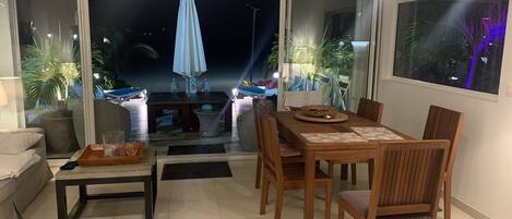 A dining area with a table and chairs, a sofa, and a small table with a tray.