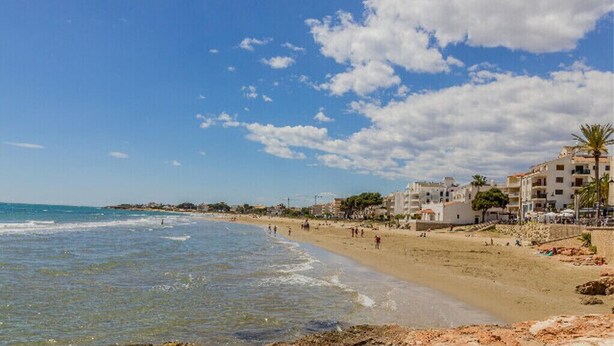 A beach with buildings in the background, clear skies, and a few clouds. - DON PEDRO APARTMENT IN ALCOCEBRE (Alcocéber)