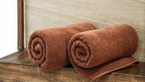 Two rolled towels on a wooden surface. - Nori House Kata Beach (Karon)