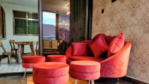 Ein modernes Wohnzimmer mit einem roten Sofa, passenden Ottomanen und einer Wand mit Muster.